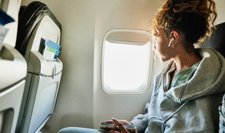 A woman sitting on a plane looking out the window